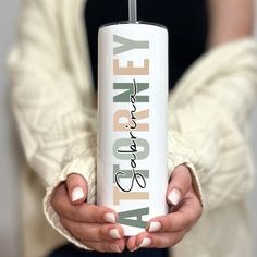 a woman holding a white travel mug with the words alofty on it