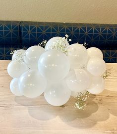 white balloons and baby's breath on a wooden table