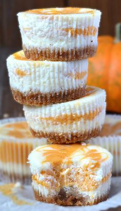 three desserts stacked on top of each other with frosting and pumpkins in the background