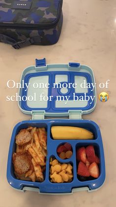 a blue lunch box filled with fruit and veggies on top of a table