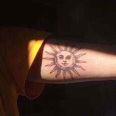 a person with a sun tattoo on their arm