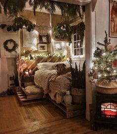 a bedroom decorated for christmas with lights and greenery