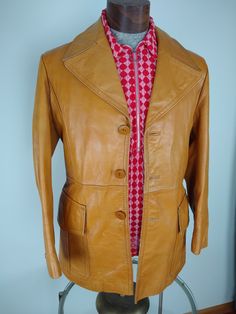 "Eye-catching 1960s/70s vintage Leather coat, minor wear on collar and shoulder (see close-up photos). Very strong durable leather in a beautiful caramel brown. Three inside pockets. Armhole to Armhole across chest 21\" Arm length from shoulder 24\" Jacket length from mid shoulder 31\"" Retro Vintage Brown Outerwear For Work, Retro Brown Outerwear For Vintage Fashion, Retro Brown Leather Outerwear, Vintage Brown Leather Jacket For Formal Occasions, Retro Brown Leather Jacket For Work, Retro Brown Formal Outerwear, Retro Single Breasted Leather Jacket, Retro Brown Outerwear For Formal Occasions, Retro Single-breasted Leather Jacket