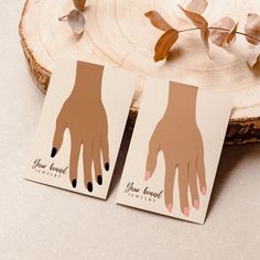 two cards with hand prints on them next to a piece of wood