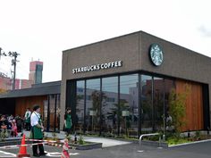 people are standing in front of starbucks coffee