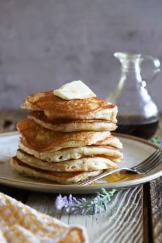 a stack of pancakes with butter and syrup on a plate