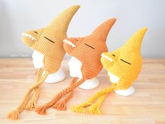 three crocheted shark hats on mannequin heads