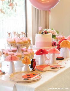 a table topped with lots of cakes and cupcakes