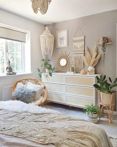 a bedroom with white furniture and plants on the wall next to the bed is decorated in neutral colors