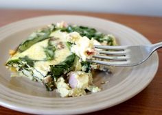 an egg, spinach and ham breakfast casserole on a plate with a fork