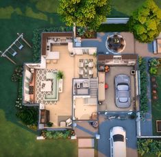 an aerial view of a house with a car parked in the driveway and lots of greenery