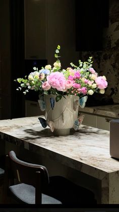 a vase filled with flowers sitting on top of a wooden table