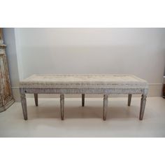 a white bench sitting in the middle of a room