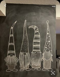 a chalkboard drawing of three gnomes standing next to each other