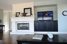 a living room filled with furniture and a flat screen tv mounted on the wall above a fireplace