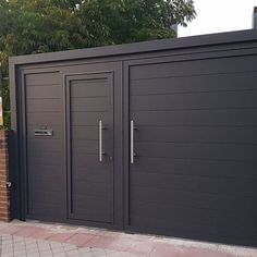 a large metal gate with two doors on each side and brick wall around it, along with a brick walkway