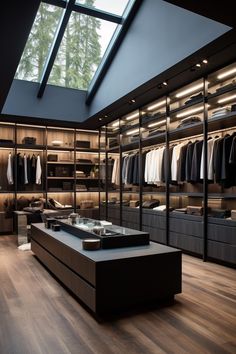 a walk - in closet with lots of clothes on shelves and drawers under a skylight