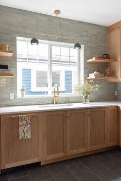 a kitchen with wooden cabinets and white counter tops next to a window in the corner