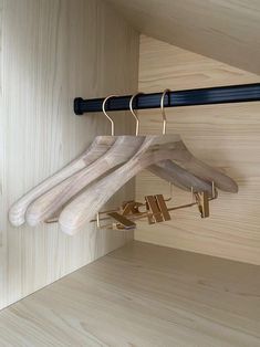 clothes hangers are hanging on the wall next to a coat rack and wooden pegs