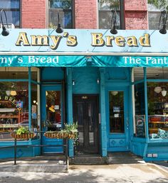 the store front of an old bakery with blue awnings