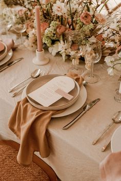 a table set with place settings and flowers