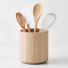 wooden utensils in a cup with spoons and whisks