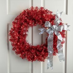 a red and silver christmas wreath on a white door