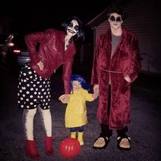 two adults and a child dressed up as the rocky show characters, one holding hands