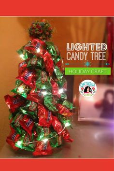 a christmas tree made out of candy bars with lights on it and the words lighted candy tree