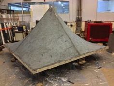 a large metal object sitting on top of a tarp in a room filled with other items