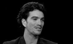 a black and white photo of a man in a suit looking off to the side