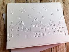 two cards with white paper on top of each other, one has houses and the other has stars