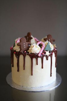 a decorated cake with white frosting and candy canes on it's top