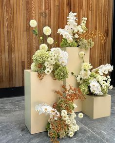 there are three vases with flowers in them on the floor next to each other