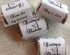 four rolls of wedding candy with the names of their bride and grooms on them