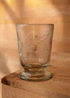 a glass cup sitting on top of a wooden table