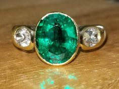 GORGEOUS 18k yellow  gold Vintage Engagement ring treated green Colombia Emerald ring .center oval shape treated green emerald weight 3.14ct. size 11.4x9.3mm nice vivid green color ,clean, very lively ,nice cut . side two oval natural sapphire total weight 1.10ct.Ring SIZE 6 Resizable Retail value $9,500 net. Cert Appraisal available Gia Certified Oval Emerald Ring In Yellow Gold, Gia Certified Oval Green Emerald Ring, Gia Certified Green Oval Emerald Ring, Gia Certified Oval Emerald Ring, Heirloom Oval Green Emerald Ring, Oval Green Emerald Ring With Center Stone, Gold Vintage Engagement Ring, Platinum Engagement Rings Vintage, Vintage Gold Engagement Rings