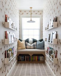 a room that has some books on the shelves in it and is decorated with wallpaper