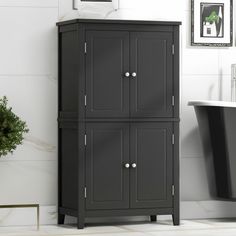 a bathroom with a black cabinet next to a bath tub