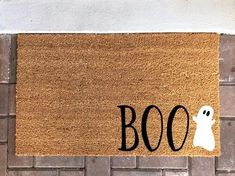 a door mat with the word boo on it and a ghost in front of it