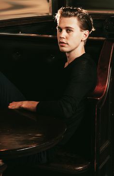 a young man sitting at a table in a restaurant