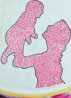 the silhouette of a woman holding a baby in her arms with pink sprinkles