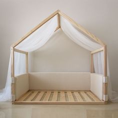 a bed made out of wood and white curtains