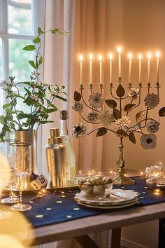 a dining room table set with candles and plates