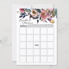 a printable wedding game with flowers on the front and back, sitting on top of a marble surface