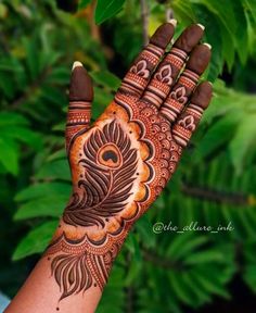 a woman's hand with henna tattoos on it