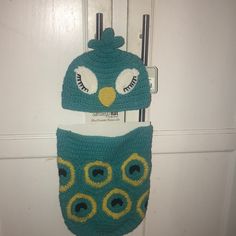 two crocheted owl hats hanging on the door