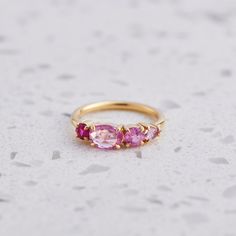 Our Splice Ring has been set with all shades of pink sapphires. Rose cut oval sapphire in centre measures 7 x 5mm. Band width 1.8mm. Gold weight in 14ct 3.1g approx. The first image is a North South facing splice, the second image is an East West facing splice. Please leave a note at the checkout of your preferred direction. Pictured with a high shine finish. Please note, we will match the sapphires as close to the image as possible, but each stone is unique and may vary in appearance and colour Pink Stone Jewelry, Pink Stone Ring, Pink Gold Sapphire Ring With Gemstone, Pink Gold Ring With Pink Sapphire, Wedding Pink Sapphire Multi-stone Ring, Pink Sapphire Ring With Ethical Diamonds, 14k Pink Gold Sapphire Gemstone Ring, Pink Sapphire Jewelry, Pink Stone Rings