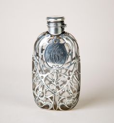 an ornate silver flask bottle on a white background with the word octopus printed on it