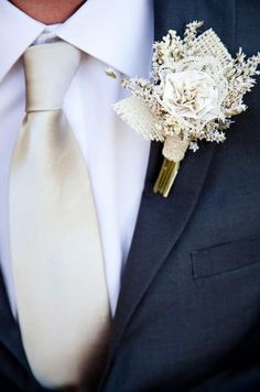 a man wearing a suit and tie with a boutonniere on his lapel